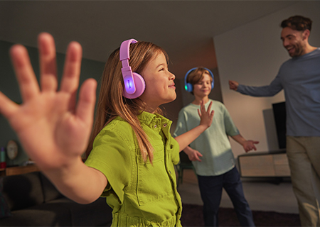 Copii care se bucură de muzică utiliz&acirc;nd căştile auriculare Philips