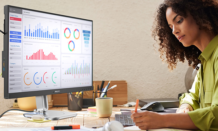 O femeie lucrează cu monitoarele Philips certificate TCO Edge.