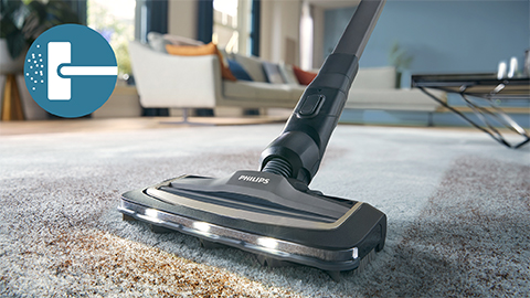 Aspiratorul fără fir Philips AquaTrio cu aspirare şi spălare seria 9000 curăţă un covor şi o carpetă