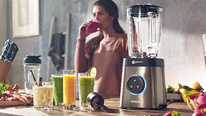 O doamnă utilizează blenderul Philips