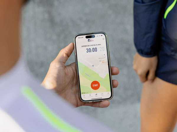 Un participant la alergare &icirc;şi verifică telefonul, aştept&acirc;nd să fie dat startul.